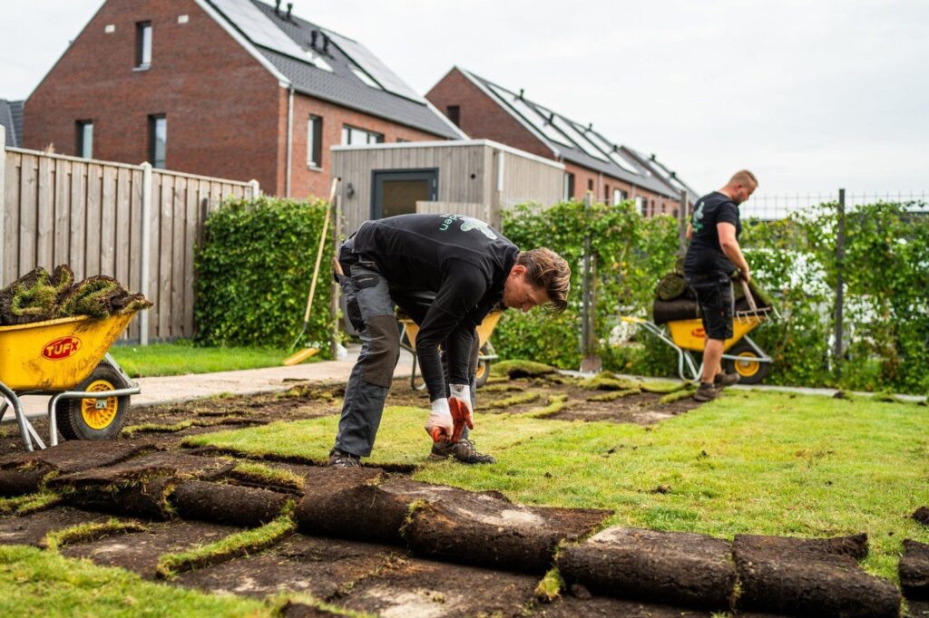Twee hoveniers aan het werk met het leggen van graszoden