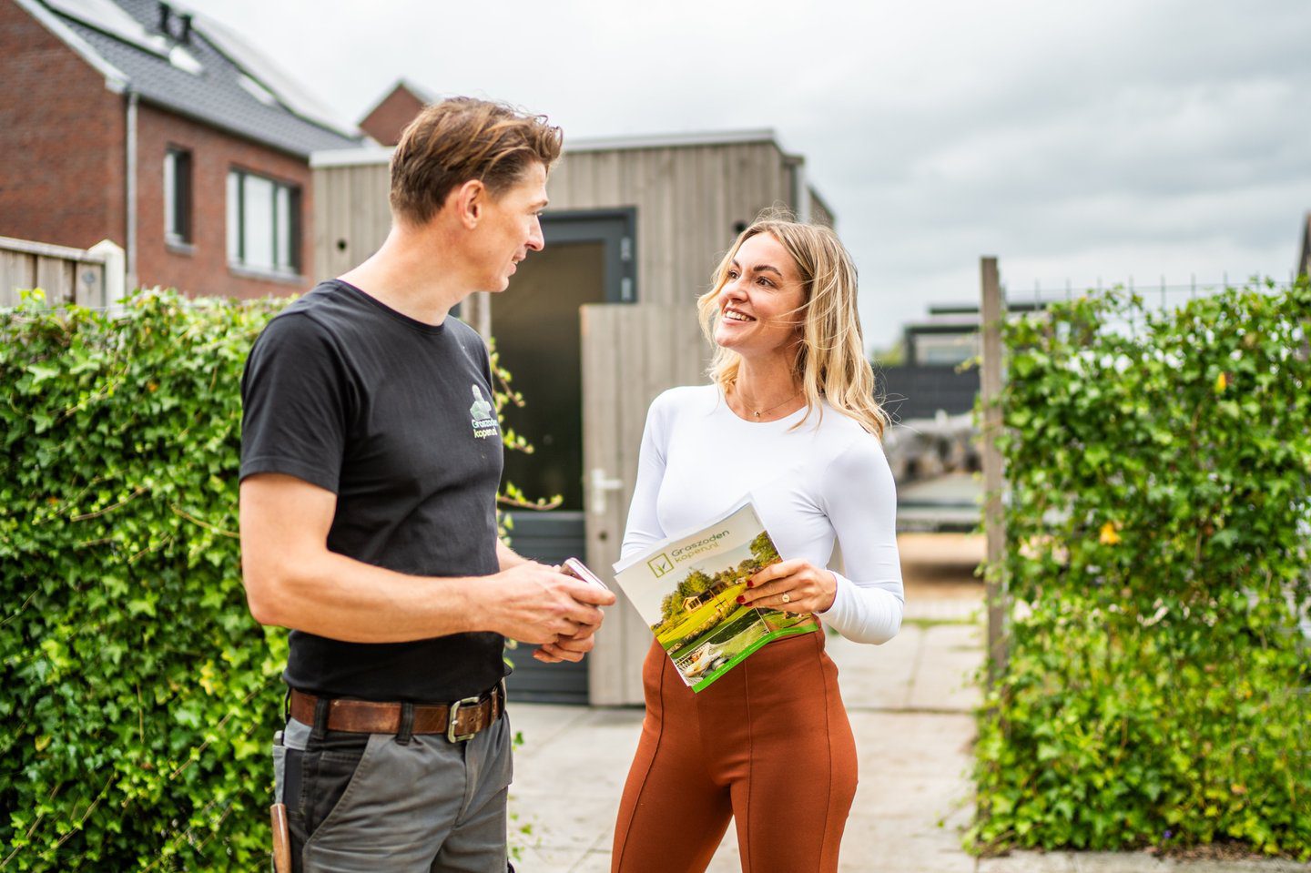 Klant in gesprek met tuinaannemer over service en garantie van graszoden