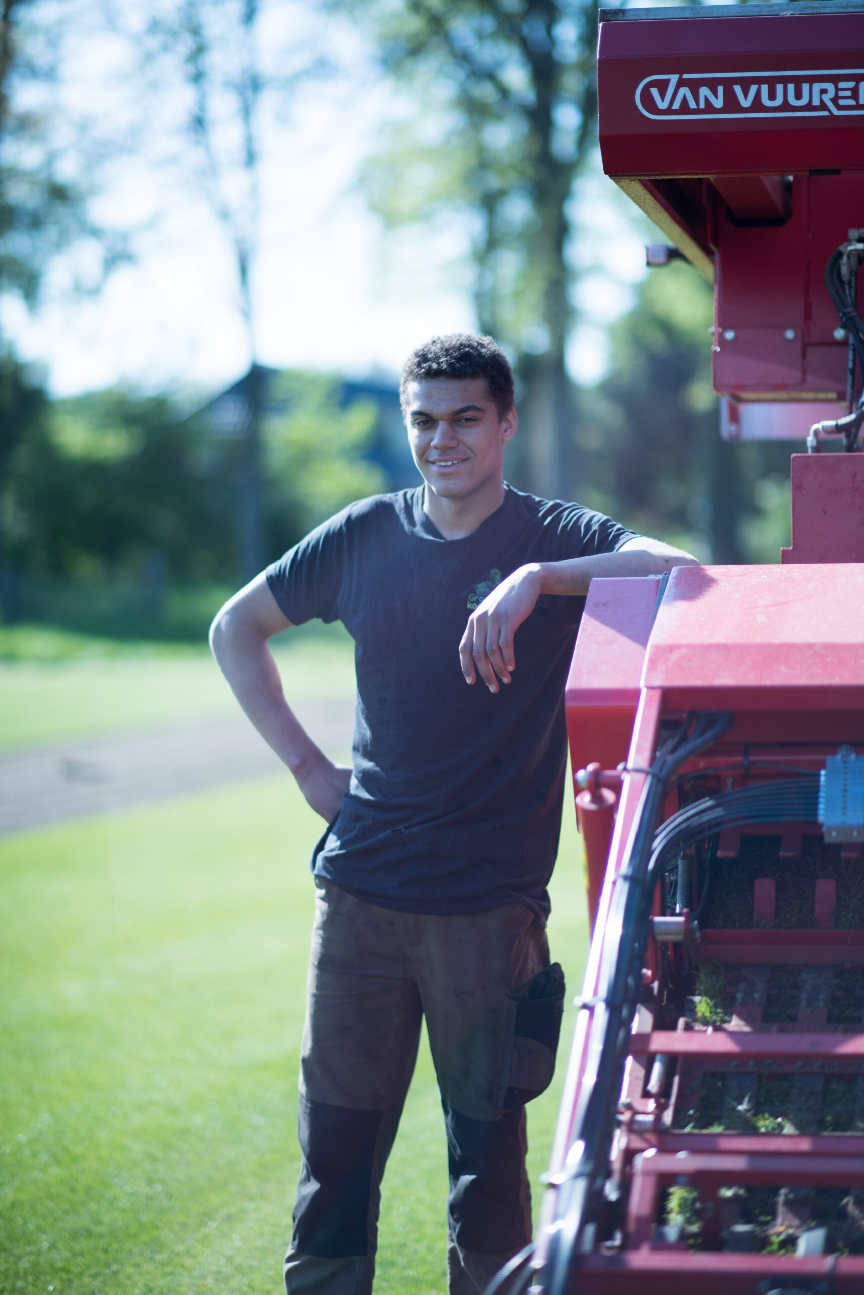 Medewerker van Graszodenkopen.be bij de graszoden-oogstmachine op het veld