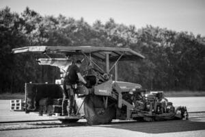 Medewerker van Graszodenkopen.be snijdt graszoden met een machine op het veld