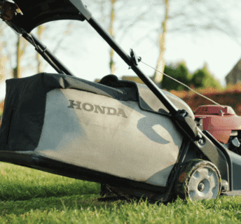 Honda grasmaaier met opvangbak tijdens het maaien van het gazon, duidelijk voorbeeld van maaien zonder mulchen.