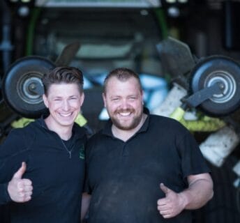 Team van graszodenbedrijf bij een machine voor het oogsten van graszoden